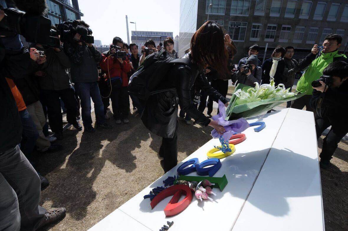 Une femme dépose des fleurs sur l'enseigne des bureaux de Google en Chine.