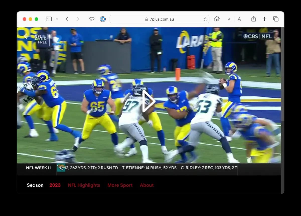 A moment from an NFL game being broadcast on 7Plus. A blue-uniformed player is throwing the football. Statistics for the game are displayed at the bottom.